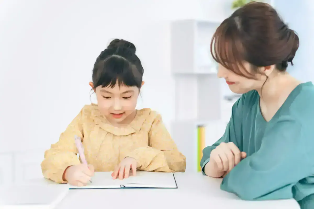 S-Project 家庭教師の指導風景 - 講師と生徒が笑顔で学習に取り組む様子